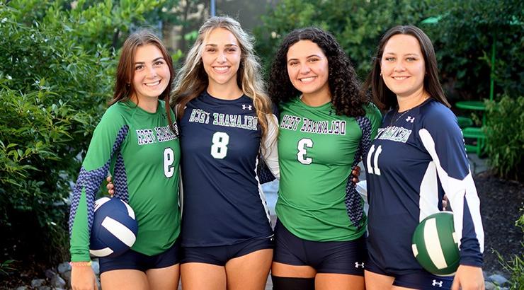 Volleyball players Morgan Donahue, Isabella Denk, Isadora Reichner, and Alexcia Sutton all standing in a line in their uniforms